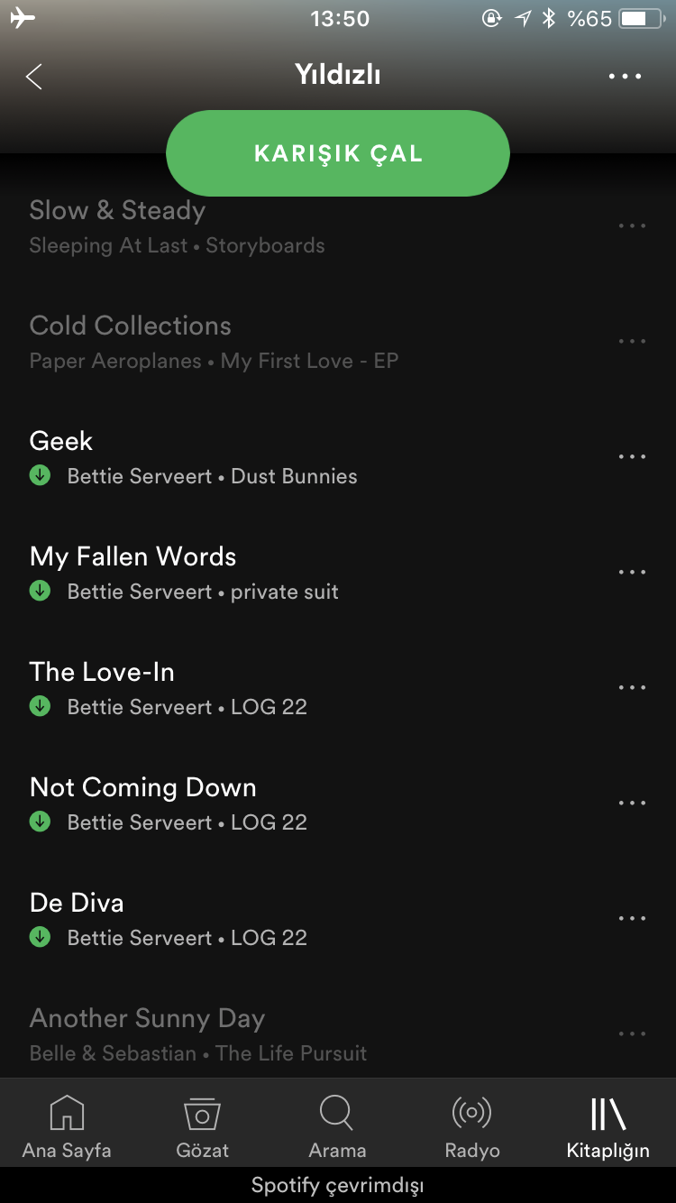 A playlist showing downloaded and unavailable songs, with the latter faded away.